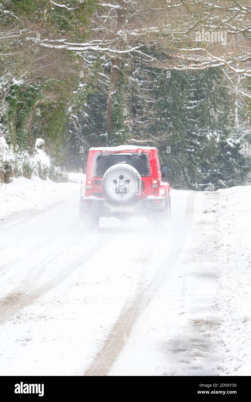 Rotes 4x4-Auto auf einer verschneiten Winterstraße, in der Nähe von Consett, County Durham, Großbritannien Stockfoto