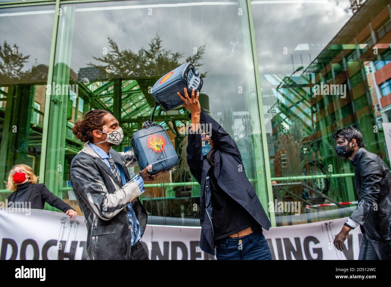 Klimaaktivisten gaben vor, aus gefälschten Ölflaschen zu trinken.das Wirtschaftsministerium (EZK) organisiert einen Klimatag mit dem Ziel, die Niederlande mit "Spitzenreitern" zu inspirieren, die Treibhausgasemissionen bis 2030 zu halbieren. Verschiedene Klimagruppen protestieren gegen die Teilnahme von Marjan van Loon, Direktor von Shell Netherlands. Im Eröffnungspanel des Klimatages. Mehrere Klimaorganisationen tauchten vor dem Gebäude des Ministeriums für Wirtschaft und Klimapolitik in Den Haag gegen Shell als Ehrengast am "Klimatag" auf. Die Klimaaktivisten wir Stockfoto