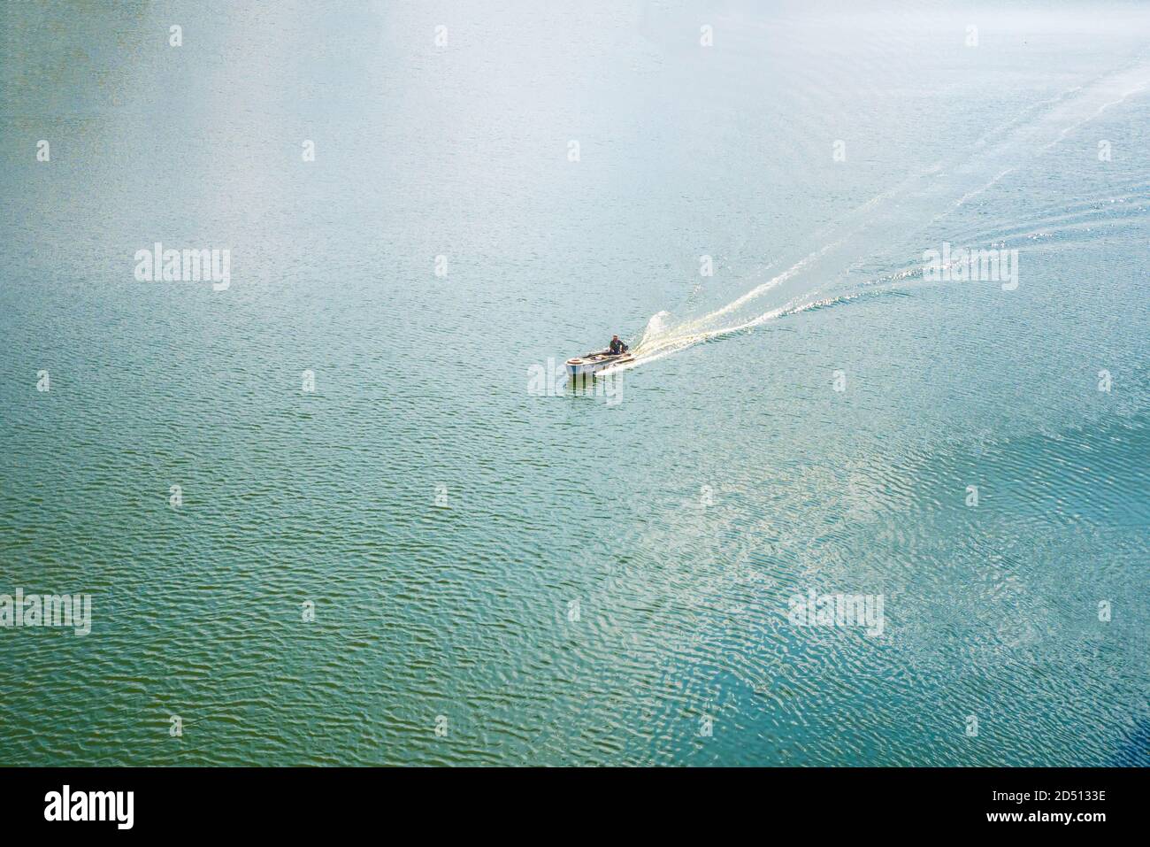 Ein einsames Fischerboot segelt zwischen dem blauen Meer. Blick von oben Stockfoto