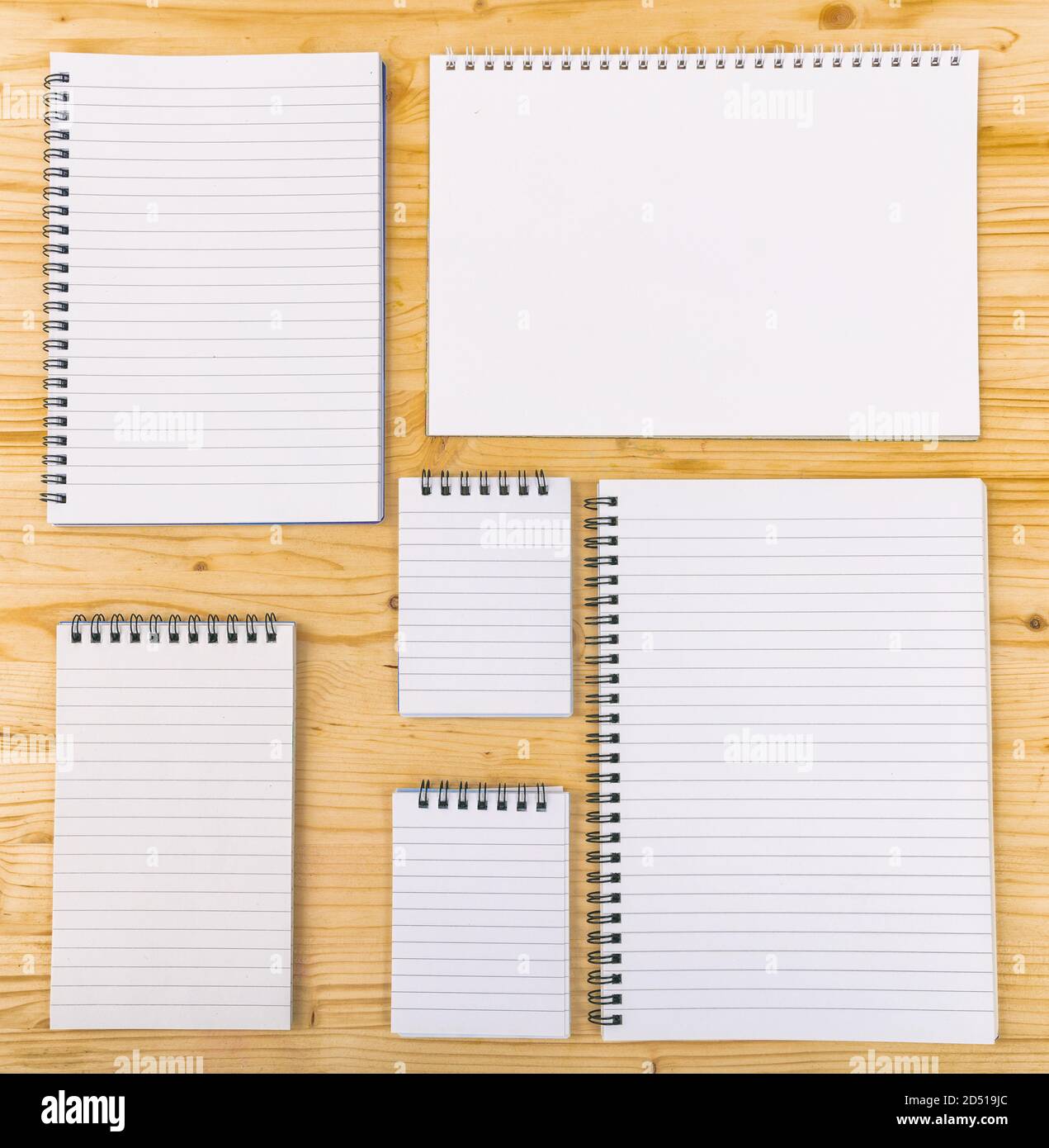 Leere Notizbücher auf Holzhintergrund, Schablone. Geöffnet Vielzahl von Spiral leere Notizblöcke, Copybooks, verschiedene Formen. Copyspace. Stockfoto