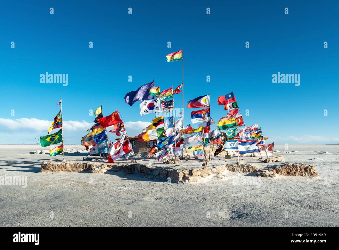 Internationale Flaggen in der Salzwüste Uyuni auf dem Standort des ersten Salzhotels, Bolivien. Stockfoto