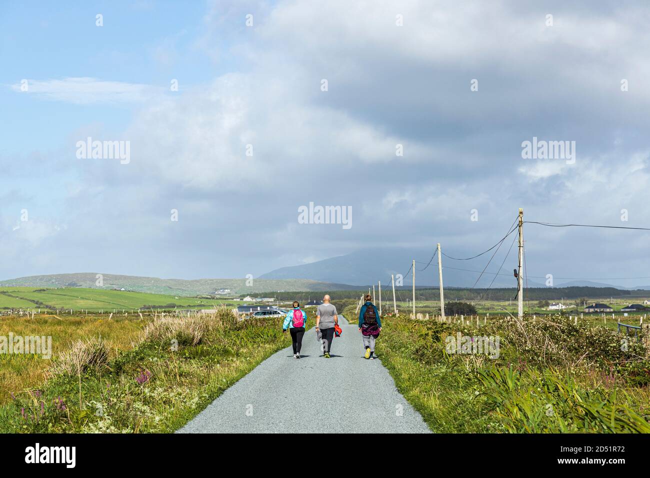 Wanderer auf einer einspurigen Straße entlang der Killeen-Schleife Spaziergänge in der Nähe von Louisburgh, County Mayo, Irland Stockfoto