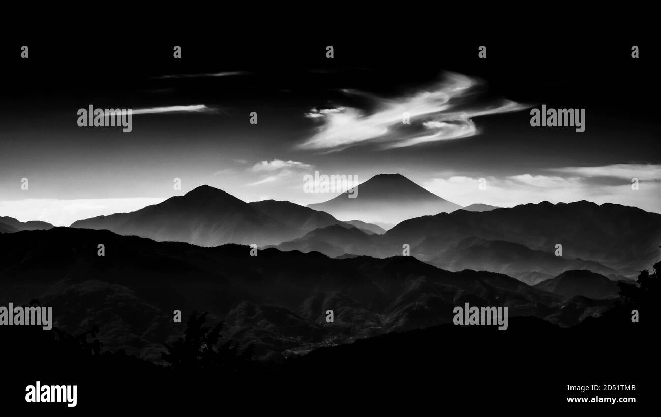 Iconic Mount Fuji eingehüllt in Nebel und Wolken wie alte Gemälde, gesehen vom Mount Takao in Japan (Schwarz und Weiß) Stockfoto