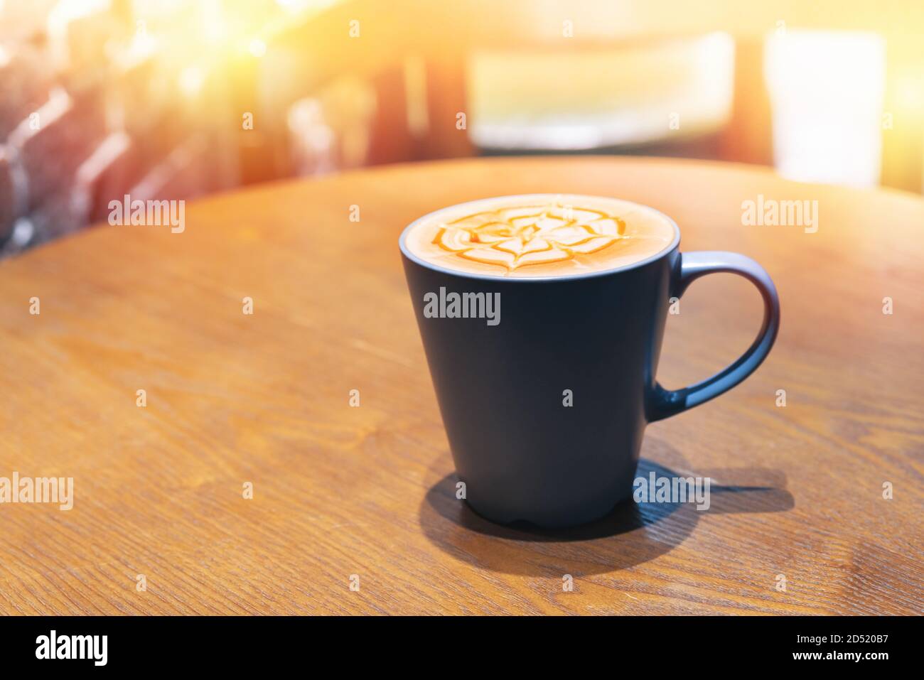 Tasse Kaffee mit Blume geformter Schaum auf hölzernen Tisch Stockfoto