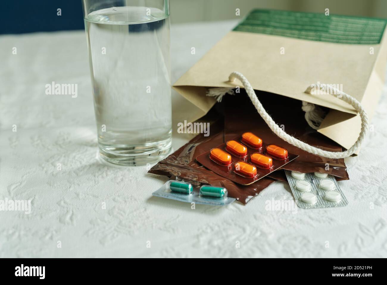 Rezept Bestellung aus dem Krankenhaus Arzt mit Medikamenten, Drogen in Plastik Zip-beutel für chronische Patienten mit Glas Wasser auf weißem Hintergrund. Stockfoto