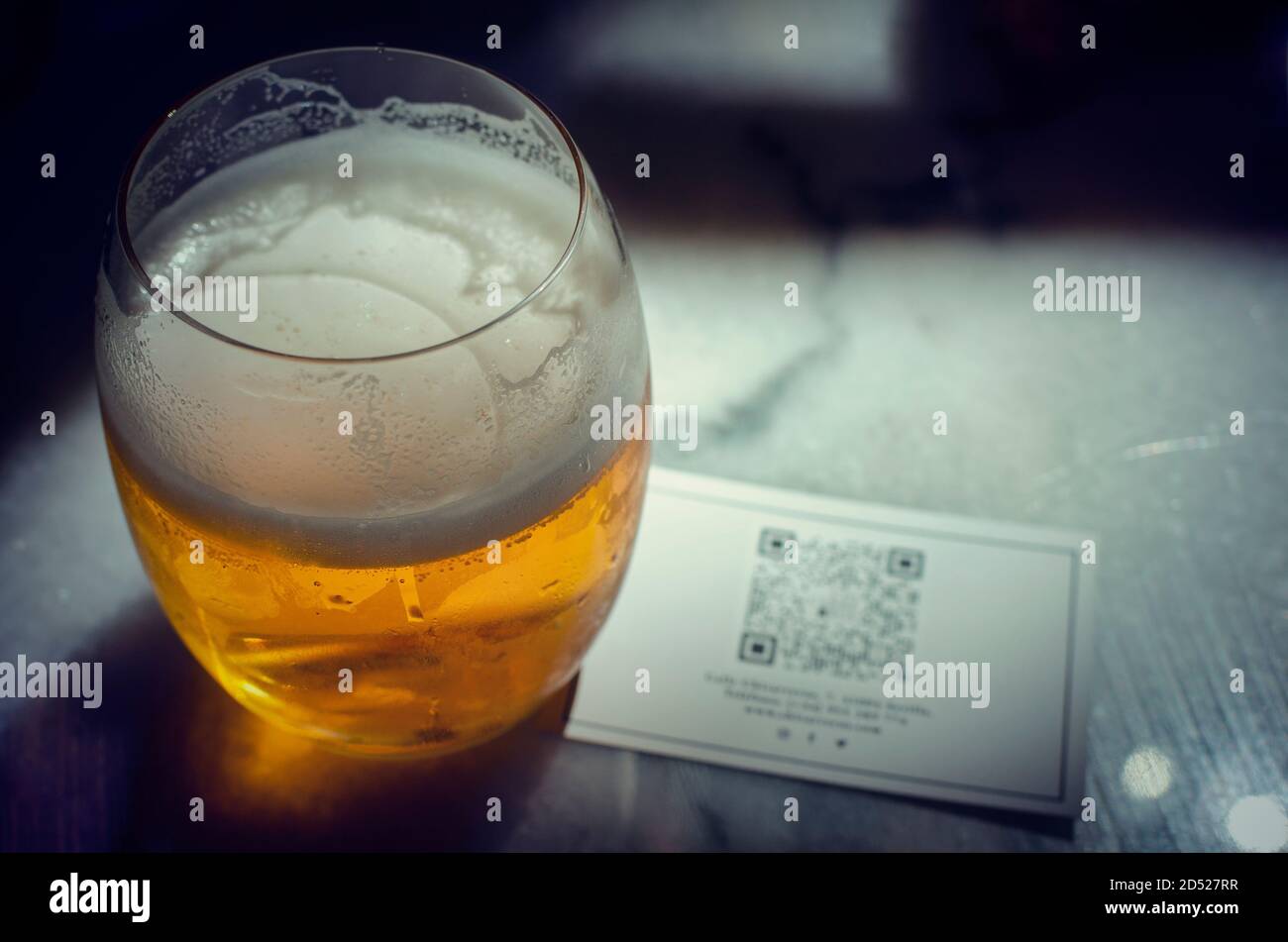 Selektiver Fokus auf ein frisches Bier mit einem QR-Code für das Online-Menü. Sommer 2020. Neuer Normalwert. Stockfoto