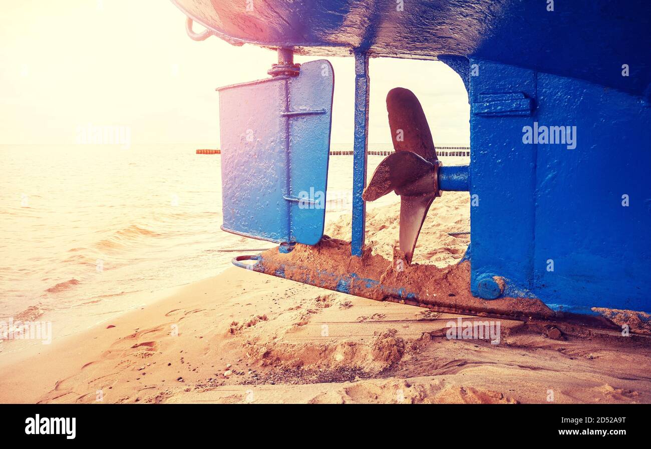 Fischerboot Ruder und Propeller am Strand bei Sonnenuntergang, selektiver Fokus, Farbtonung angewendet. Stockfoto