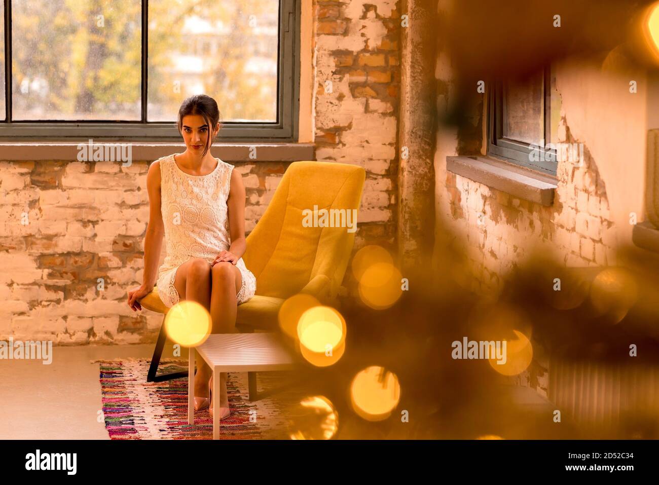 Porträt einer schönen Frau mit Bokeh Leuchten aus Weihnachtsdekoration in einem industriellen Loft. Stockfoto