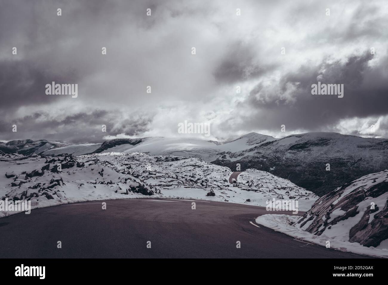 Enge Abbiegung auf der engen Bergstraße mit Schnee, Berglandschaftsblick mit Bus in der Ferne, Norwegen Dalsnibba Stockfoto