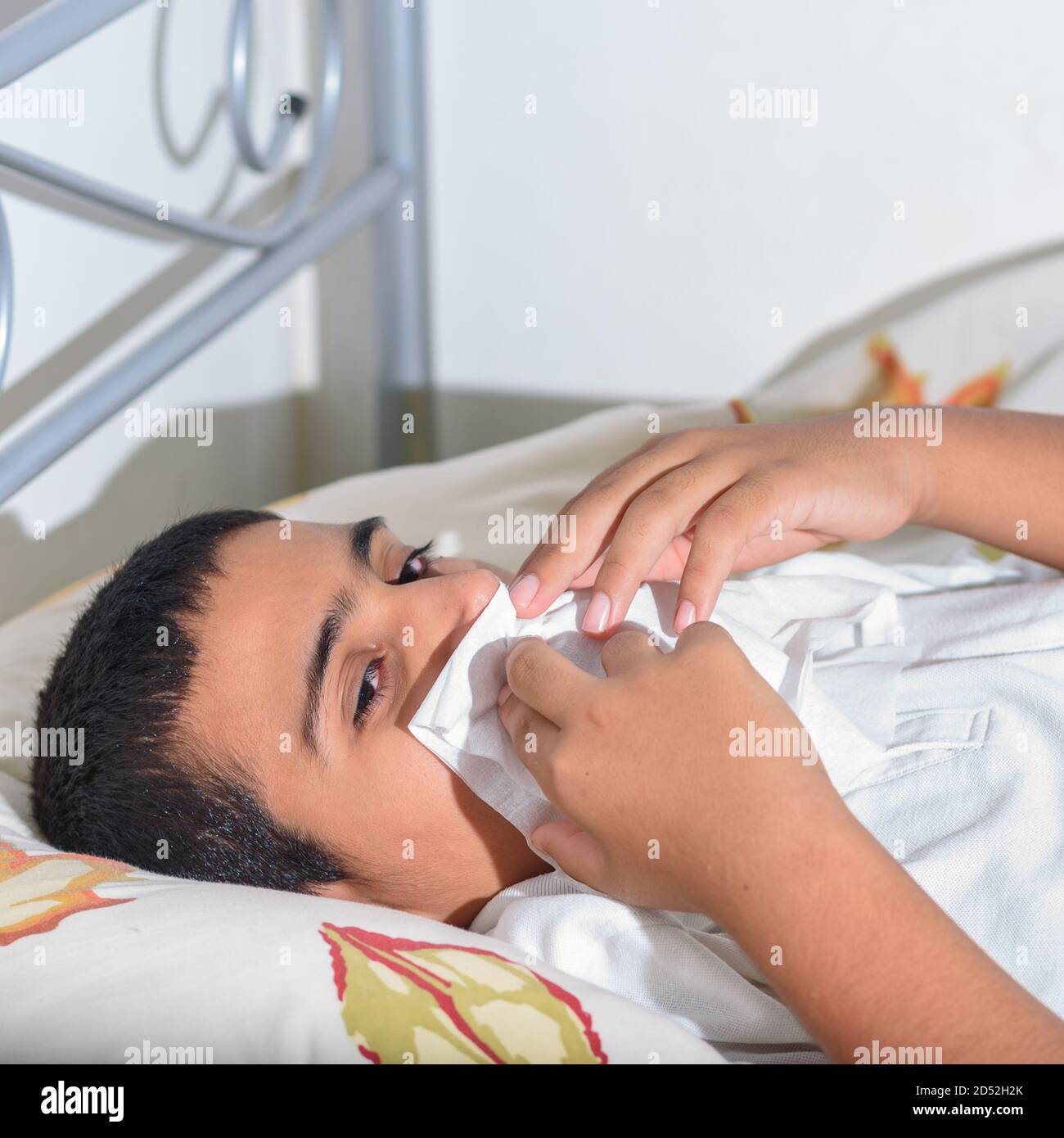 Gesundheitswesen, Virus, Grippe, Allergie, Hygiene und Menschen Konzept. Kranker Teenager, der zu Hause mit der Nase auf Papierserviette bläst. Stockfoto