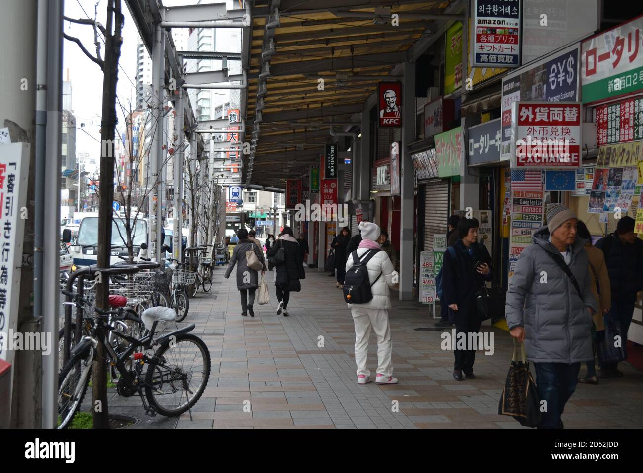Tokyo, Japan-2/24/16: Das tägliche Leben in Tokyo, Leute, die die Straßen entlang gehen und verschiedene Dinge tun; auf der rechten Seite sehen wir mehrere Geschäfte, Restaurants, etc. Stockfoto