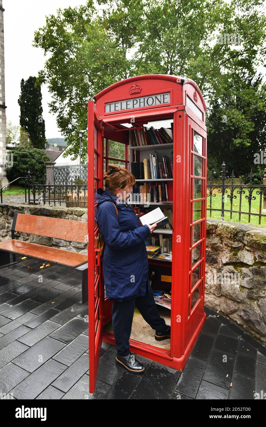 Rote britische Telefonbox, die als kostenlose Bücherei in Linz, Deutschland, Stockfoto