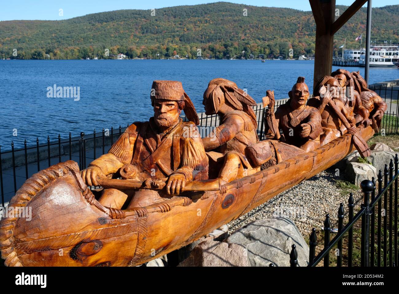 Kanuskulptur zeigt Robert Rogers und fünf Mohicans, die in Lake George, NY, ein Kanu im Birkenrindenstil paddeln. Geschnitzt von Paul stark Stockfoto