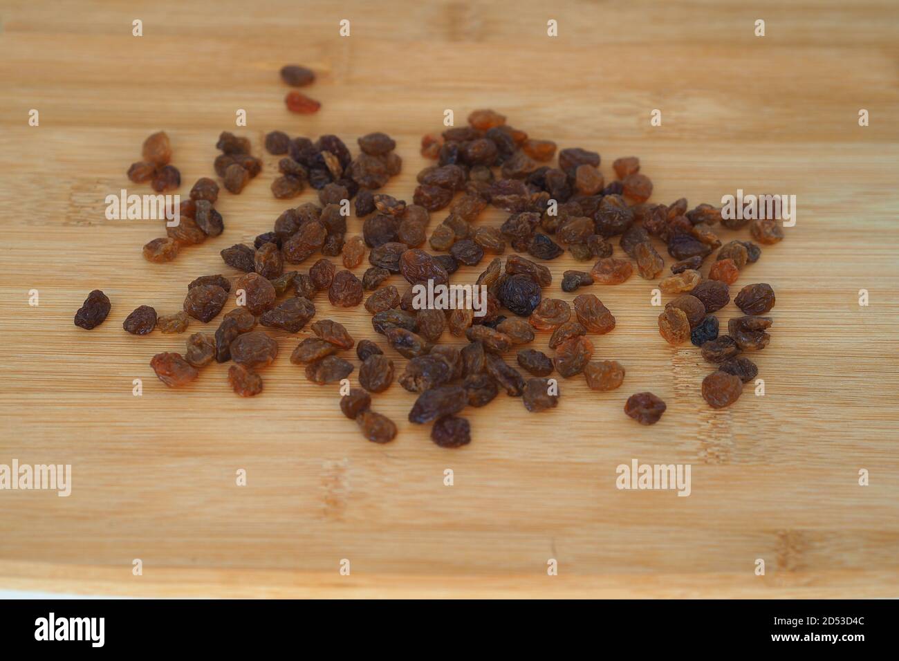 Dunkle Rosinen auf einem Holzbrett. Naturprodukte. Stockfoto