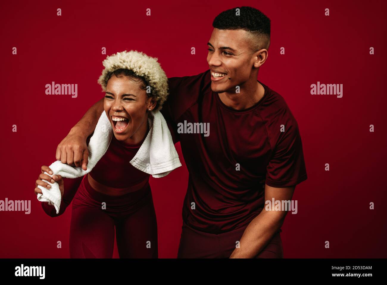 afroamerikanischer Mann und Frau mit Spaß nach dem Training. Paar entspannen und lachen nach dem Training stehen auf kastanienbraunen Hintergrund. Stockfoto