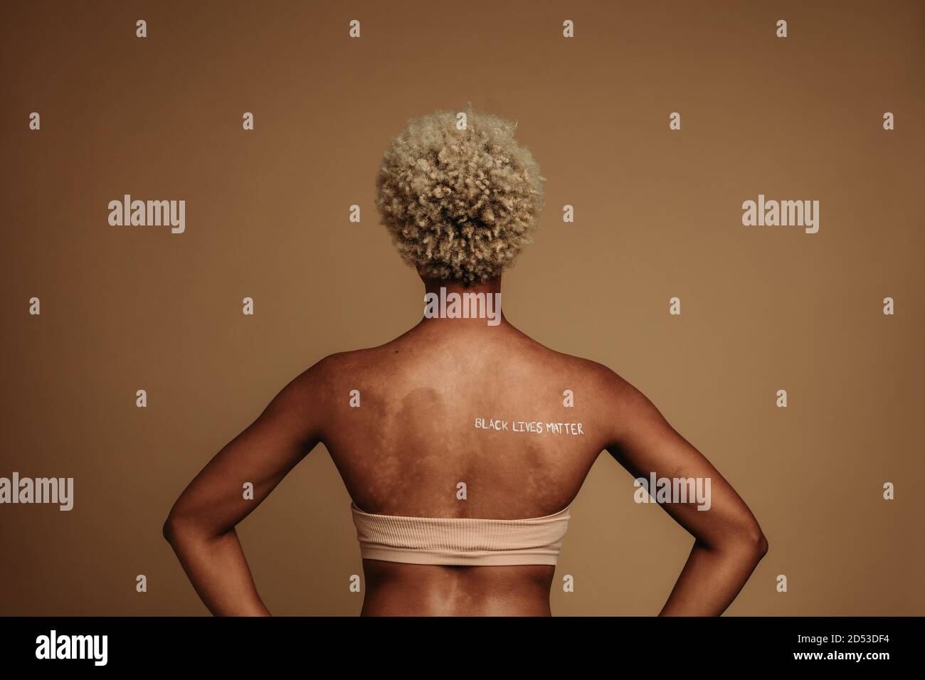 afroamerikanische Frau, die sich mit Schreiben auf dem Rücken widerlegt. Rückansicht der Frau stehend mit Worten schwarz Leben Materie auf der Rückseite geschrieben. Stockfoto