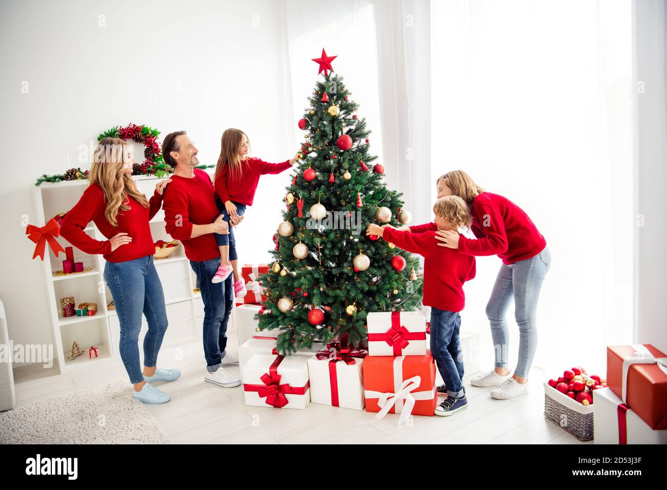 Foto der ganzen großen Familie fünf Leute treffen drei kleine Kinder Papa halten Tochter schmücken x-Mas Baum Spielzeug Bälle Stern Tragen Sie roten Pullover Jeans zu Hause Stockfoto