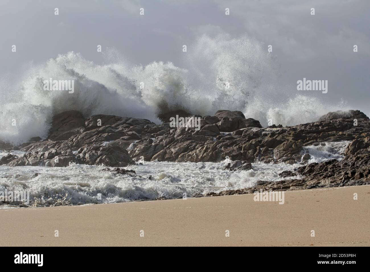 Große Wellen planschen an einem felsigen Strand im Norden portugals Stockfoto