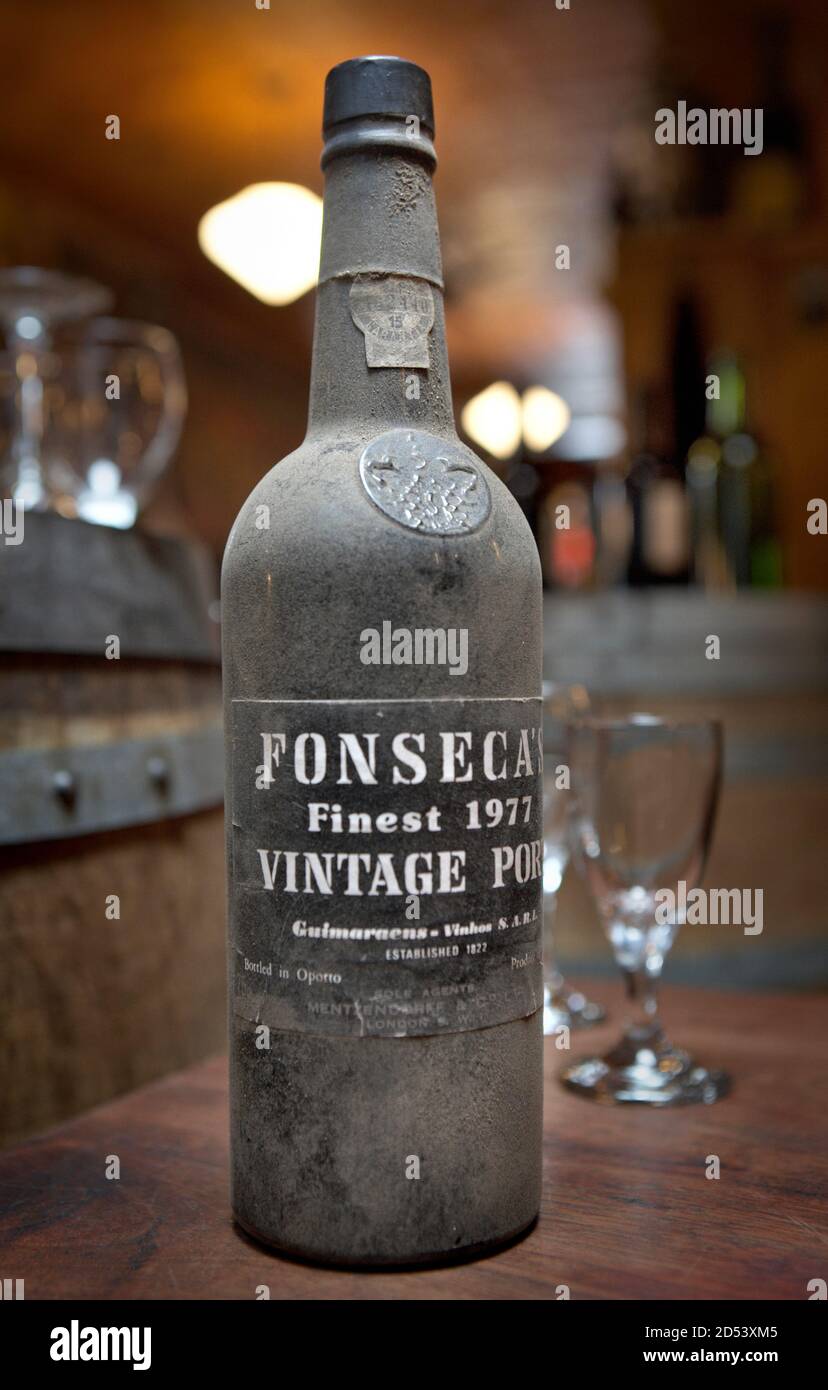 Staubige Vintage Flasche Fonseca Portwein auf einem fotografiert Holztisch in einem Weinkeller Stockfoto
