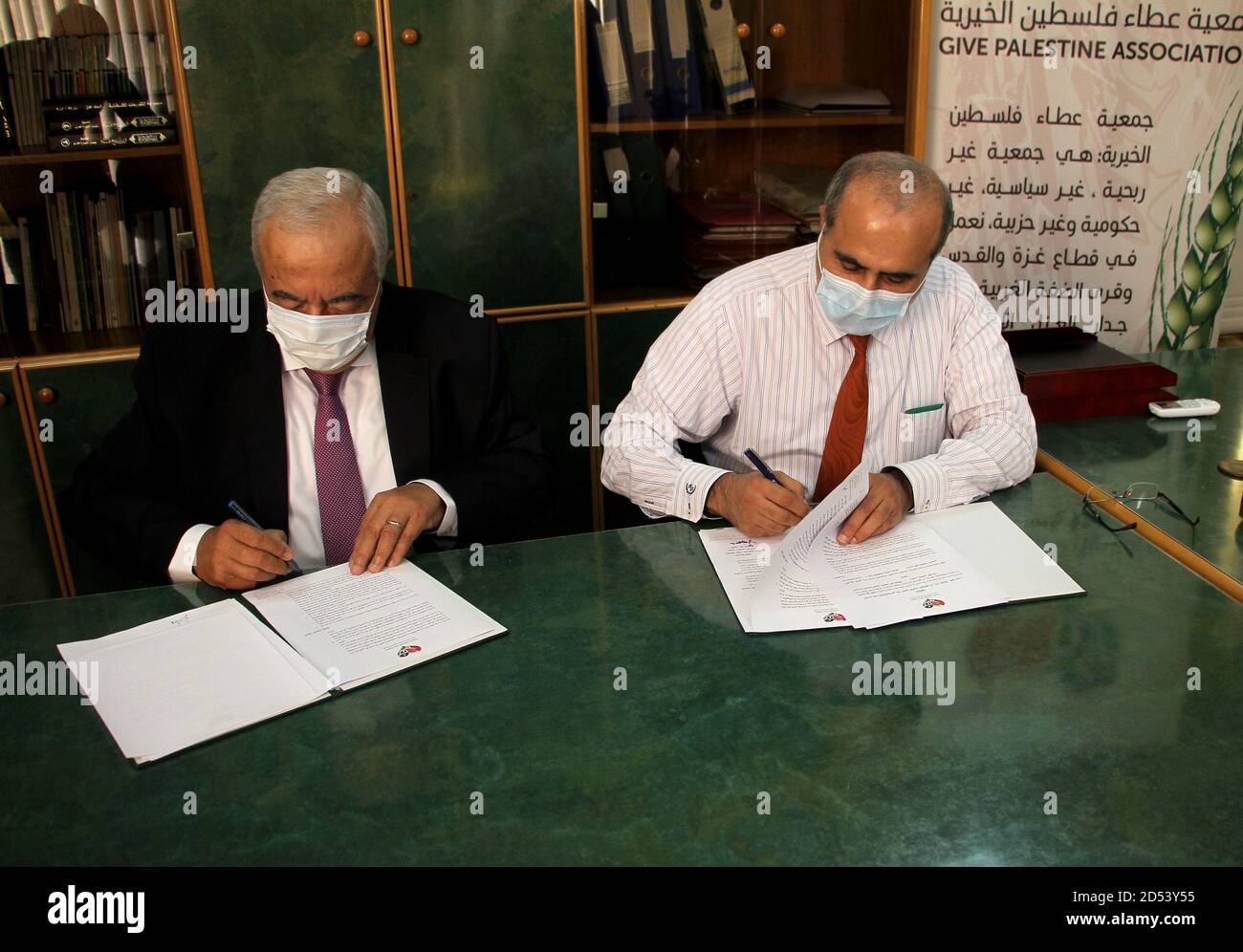 Gaza. Oktober 2020. Abdul Latif al-Haj (R), Direktor für Krankenhausangelegenheiten im Gesundheitsministerium von Gaza, und Maamoun Abu Shahla, Vorsitzender der Wohltätigkeitsorganisation Give Palestine Association, unterzeichnen am 12. Oktober 2020 in Gaza-Stadt eine Vereinbarung. Eine palästinensische Wohltätigkeitsorganisation unterzeichnete am Montag einen Vertrag mit dem Gesundheitsministerium von Gaza, um chinesische Solarzellen für ein Kinderkrankenhaus in Gaza-Stadt zu liefern und zu installieren. Kredit: Rizek Abdeljawad/Xinhua/Alamy Live Nachrichten Stockfoto