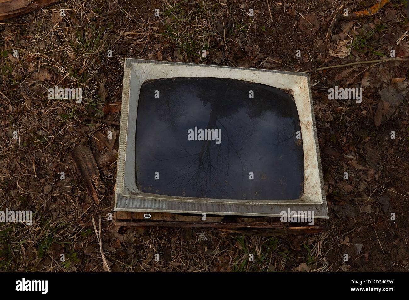 Alter kaputter Fernseher auf dem Boden mit schwarzem Bildschirm. Stockfoto