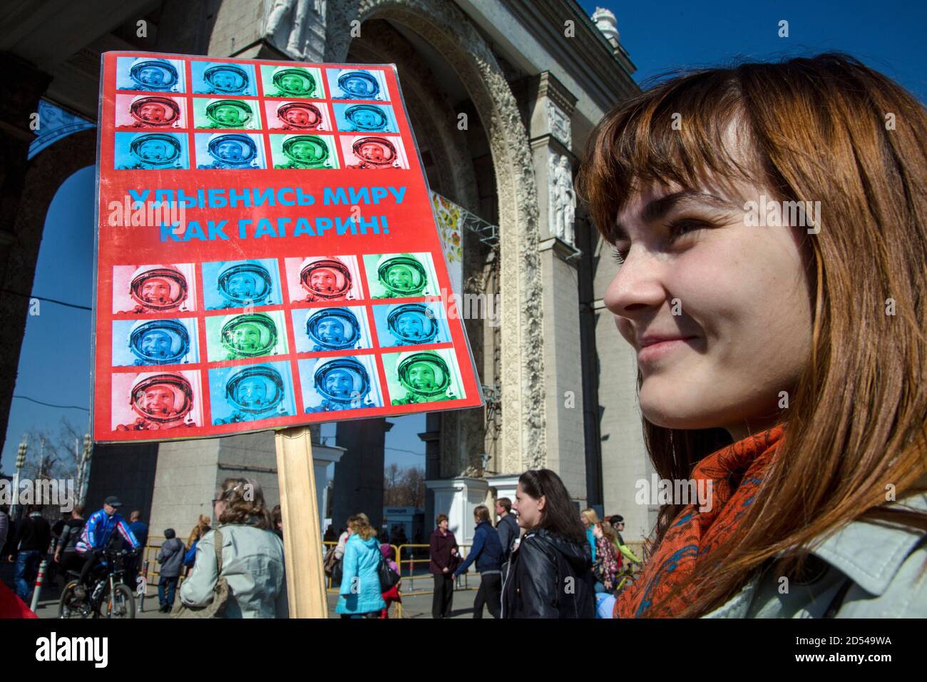 Russland, Moskau, 12. April 2015: Die Teilnehmer der Sternenparade halten Portraits des ersten Kosmonauten Juri Gagarin am Tag der Kosmonauten vor der zentralen Gasse bei der Ausstellung der Errungenschaften der Volkswirtschaft in Moskau ab. Eine Frau hält ein Banner mit der Aufschrift "Mile at the world like Gagarin" Stockfoto