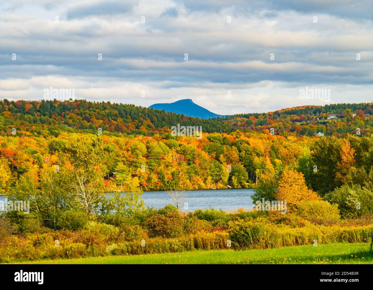 Der Iroquoissee ist von Wäldern in leuchtenden Herbstfarben umgeben Mit Camel's Hump Mountain in der Ferne Stockfoto