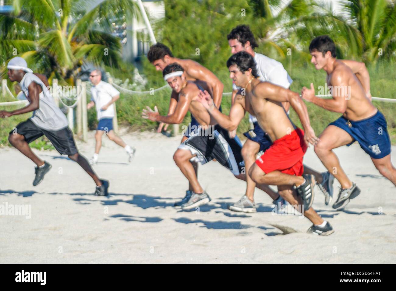 Miami Beach Florida, College-Baseballspieler trainieren Laufen sprinting öffentlichen Strand Sand, Amerikaner hispanischen schwarz afrikanischen Studenten ein Stockfoto