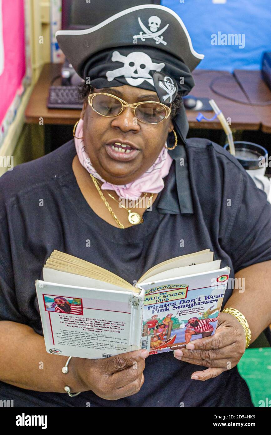 Miami Florida, Overtown, Frederick Douglass Elementary School, Lehrerin Frau weiblich gekleidet Outfit, literarische Kostüm Lesen Buch fiktive Figur, Blac Stockfoto