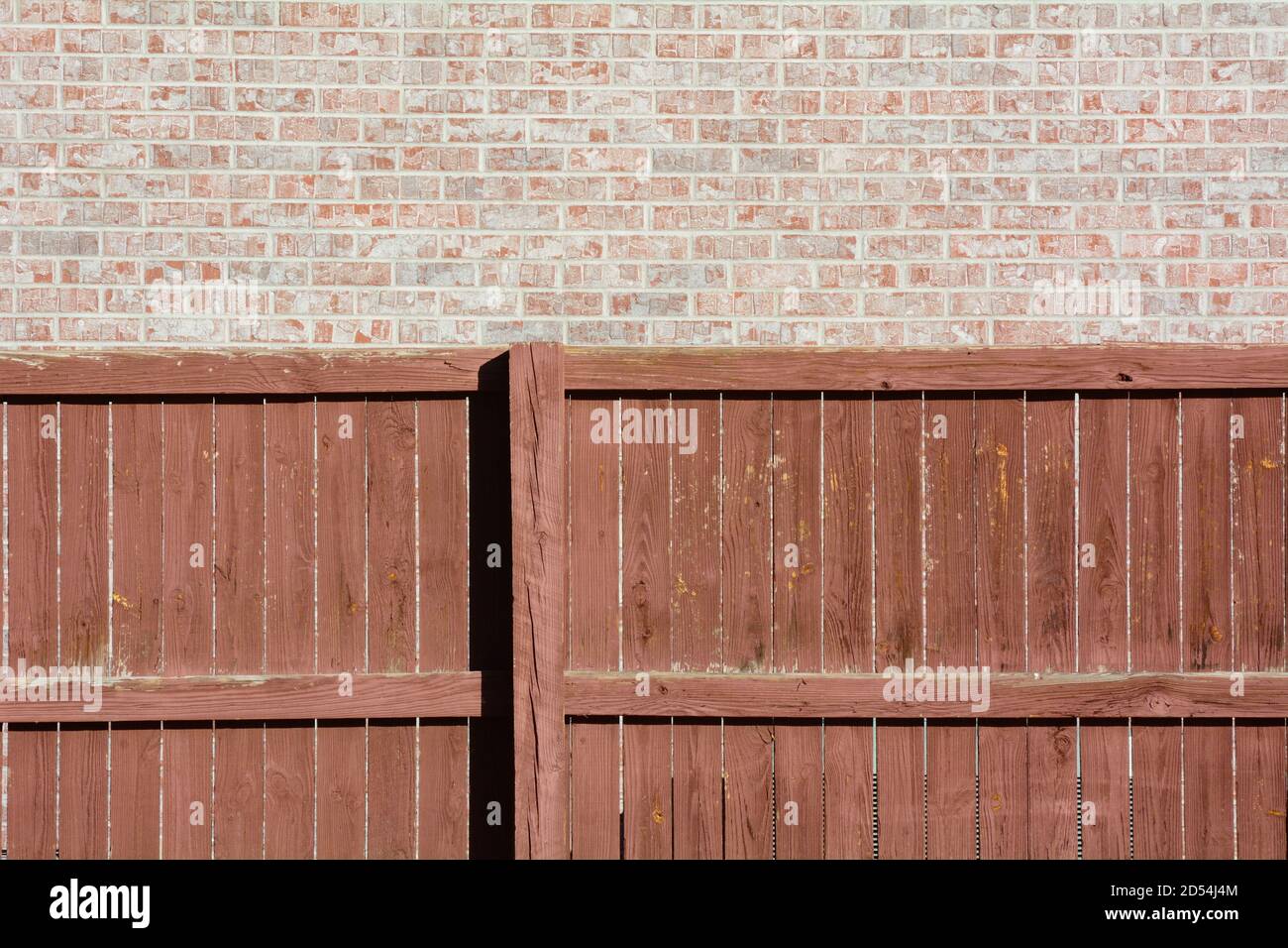 Texturierter Hintergrund von braun verwitterten Holzzaun und Ziegelwand Stockfoto