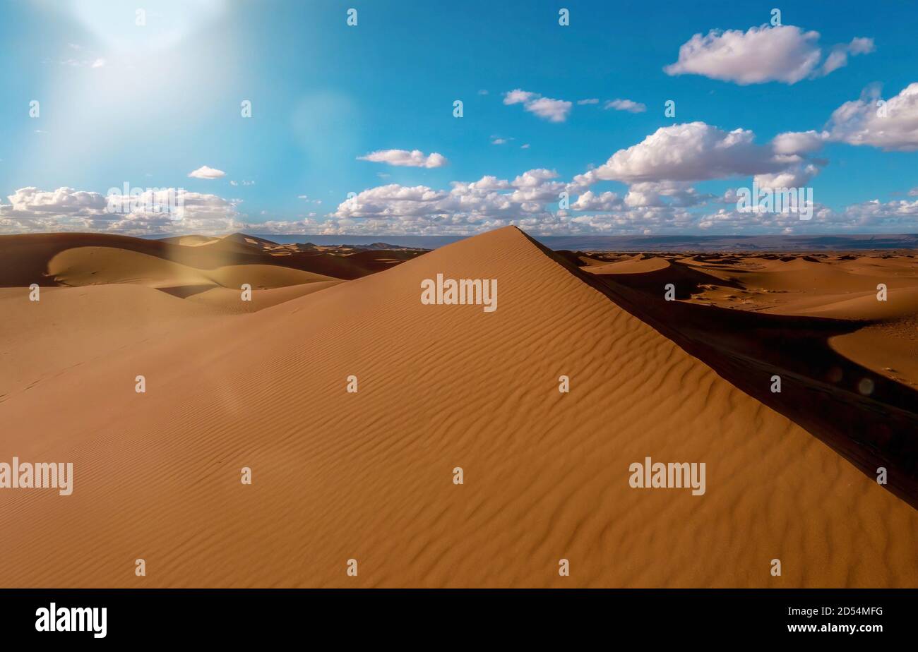 Eine wunderschöne Sahara-Wüstenlandschaft in Marokko, mit einer großen Sanddüne in Form einer Pyramide in der Mitte. Stockfoto
