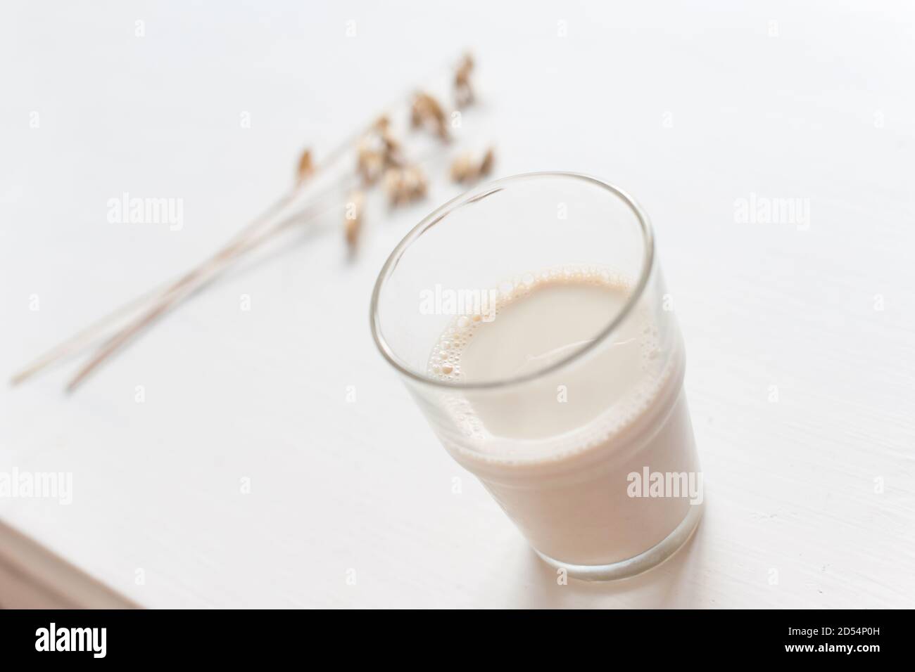 Ein Glas Hafermilch und ein Hauch Hafer Auf dem Tisch Stockfoto