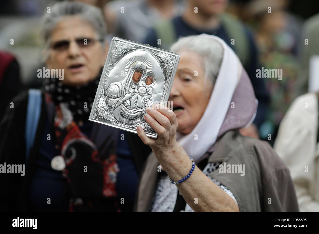 Bukarest, Rumänien - 10. Oktober 2020: Details mit einer älteren Frau, die während einer politischen Kundgebung eine orthodoxe Kirchenikone hält. Stockfoto