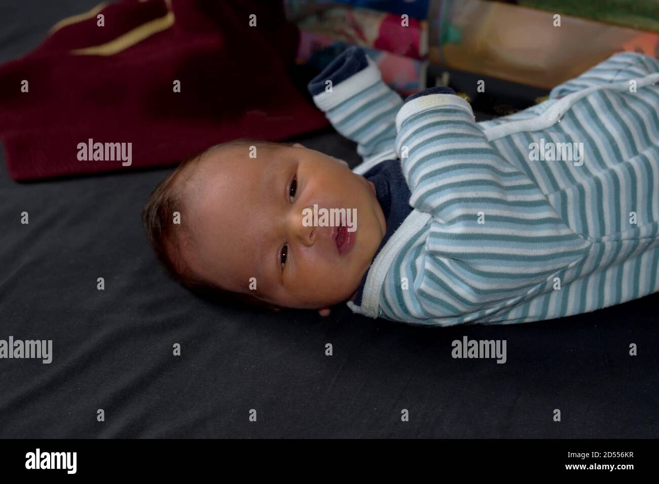 Nahaufnahme von niedlichen neugeborenen Baby mit Schal und Bücher in Hintergrund Stockfoto