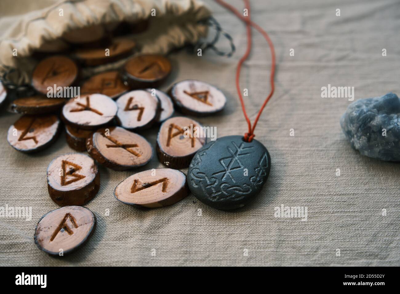 Hölzerne Runen in einem Leinwandbeutel mit einem steinernen Runescript Stockfoto