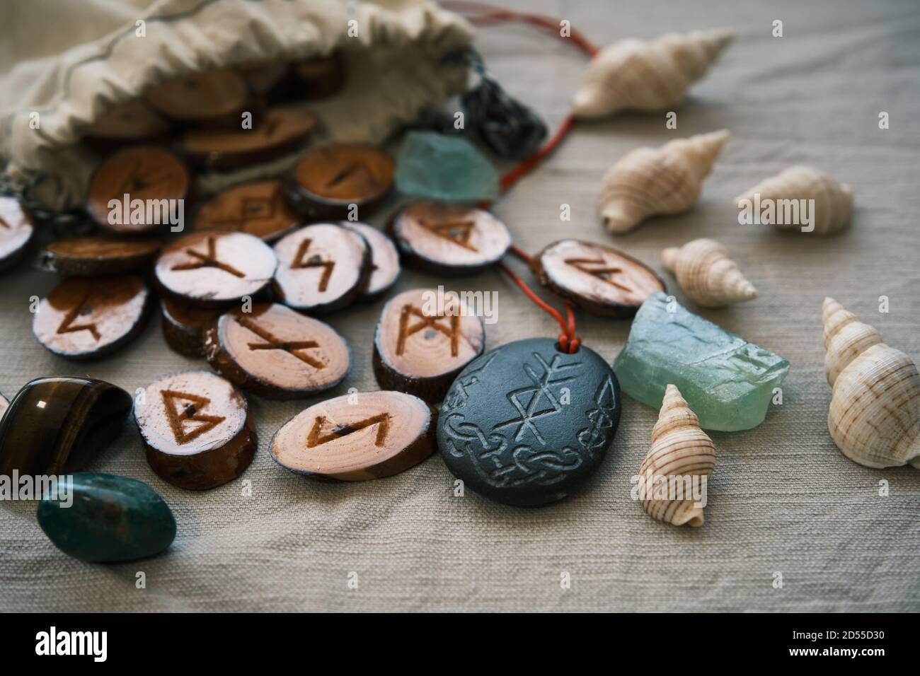 Hölzerne Runen in einem Leinwandbeutel mit einem steinernen Runescript Stockfoto