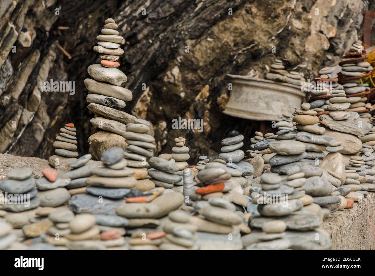 Schöne Nahaufnahme von mehreren Stein cairns sitzen auf einem viel größeren Felsen am zerklüfteten Kiesstrand an der Ostküste von Vernazza in den Cinque... Stockfoto