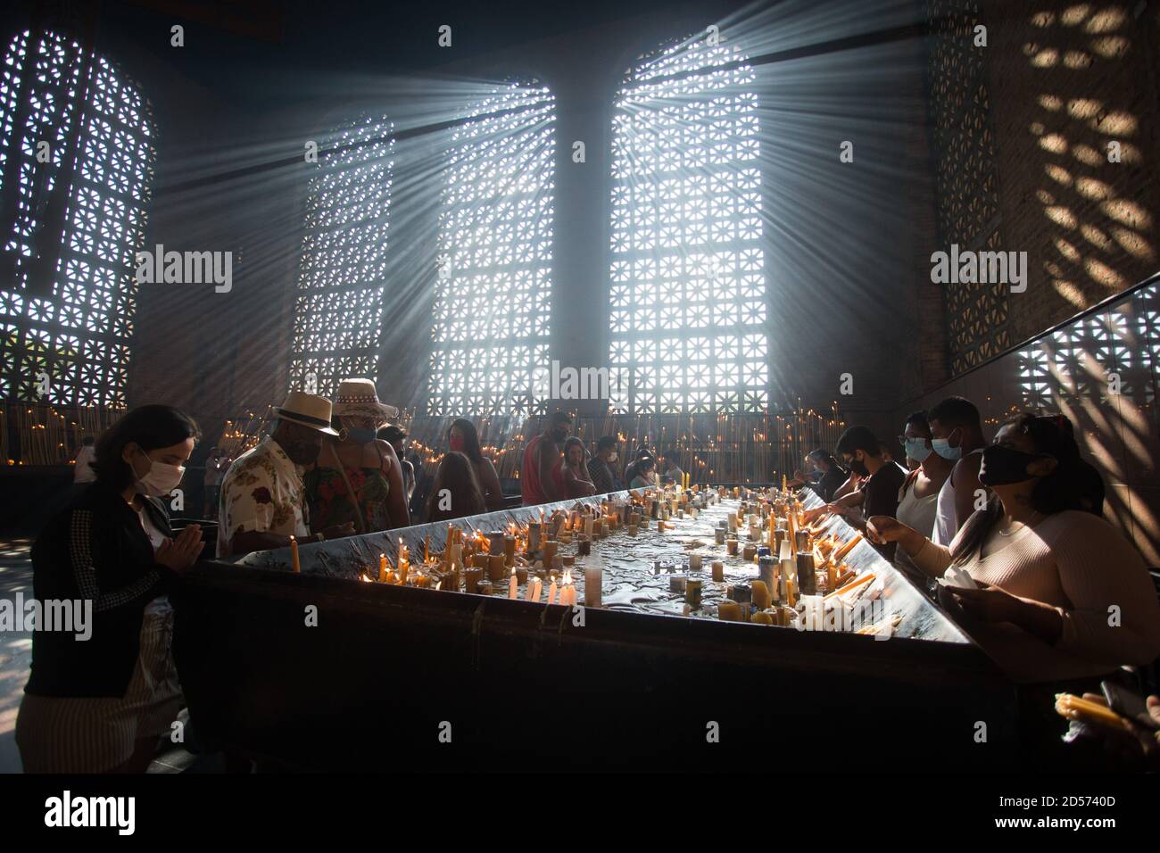 Aparecida, Brasilien. Oktober 2020. Gläubige zünden ihre Kerzen an und beten im Kerzenraum der Basilika von Nossa Senhora Aparecida, während des Tages von Nossa Senhora Aparecida, der schutzpatronin Brasiliens. Zum ersten Mal in der Geschichte der Basilika mussten wegen der Corona-Pandemie die Messen hinter verschlossenen Türen oder in Anwesenheit einer kleinen Anzahl von Menschen gefeiert werden. Quelle: Fernando Souza/dpa/Alamy Live News Stockfoto