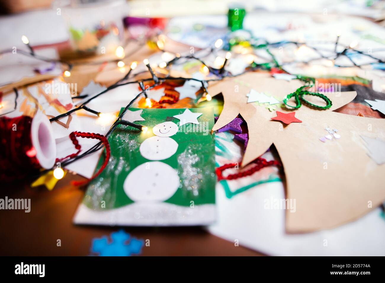 Kinderbilder und Weihnachtspapier Kunst und Handwerk auf dem Tisch. Stockfoto
