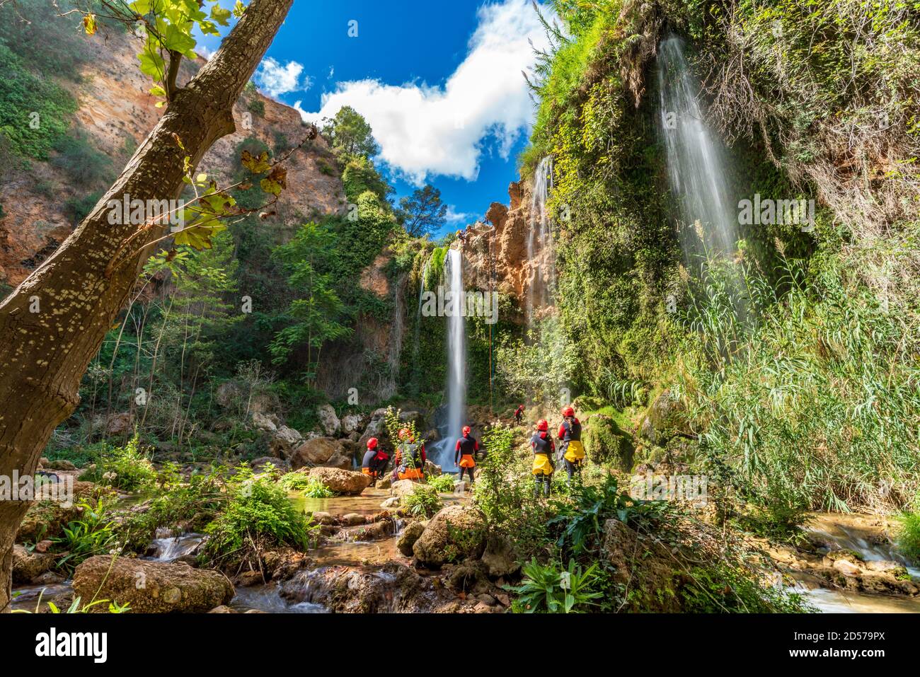 Eine große Gruppe von Menschen genießt den Wasserfall-Abstieg mit Seilen Stockfoto