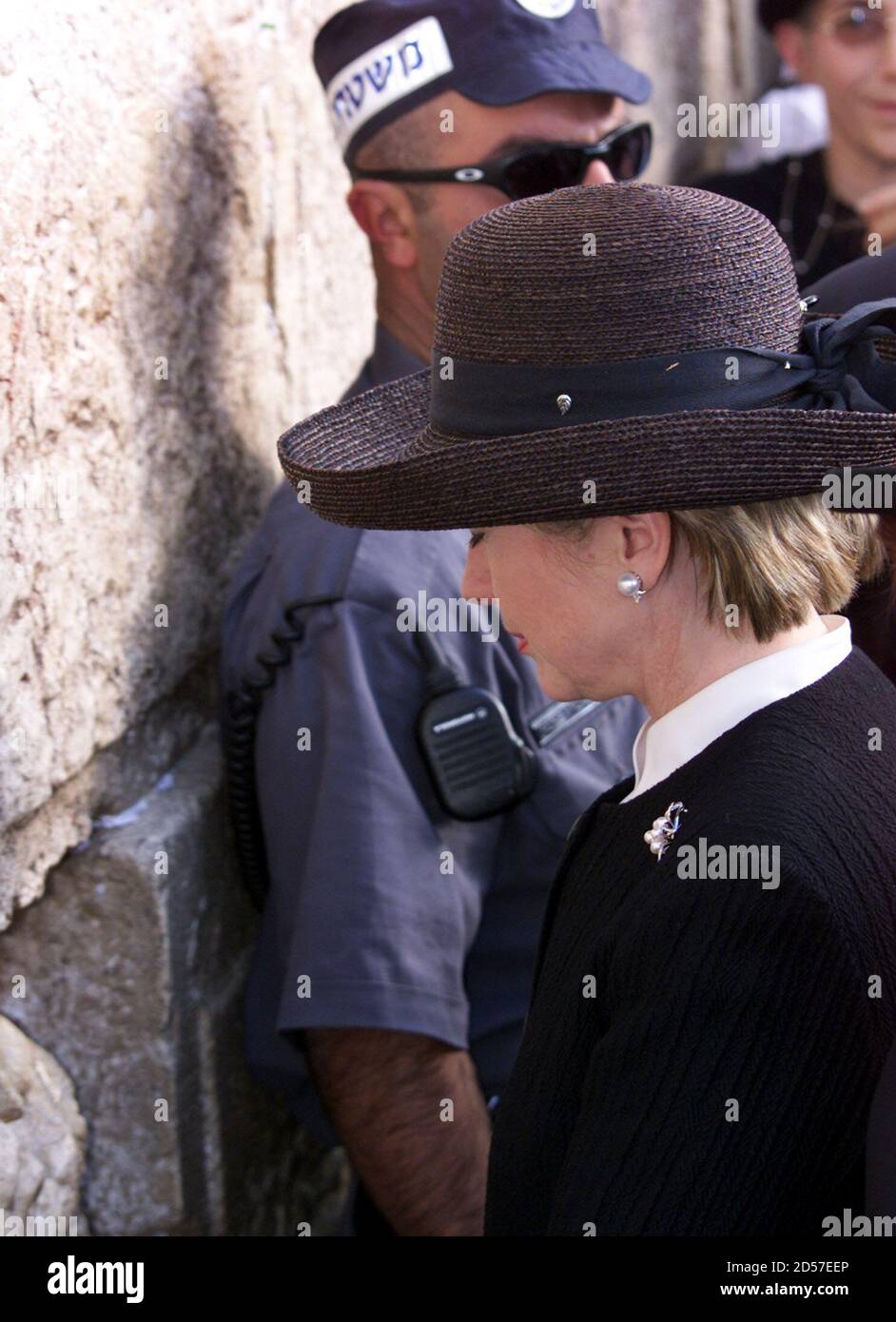Vereinigten Staaten erste Dame Hillary Rodham Clinton betet mit ihren Augen geschlossen vor der Klagemauer, wie eine israelische Polizist steht hinter beobachten die Menge November 11. [Heute, am zweite Tag ihrer offiziellen besuchen, Mrs. Clinton traf die Palästinenser First Lady in Ramallah. Später am Abend reist sie nach Jordanien. ] ??» Stockfoto