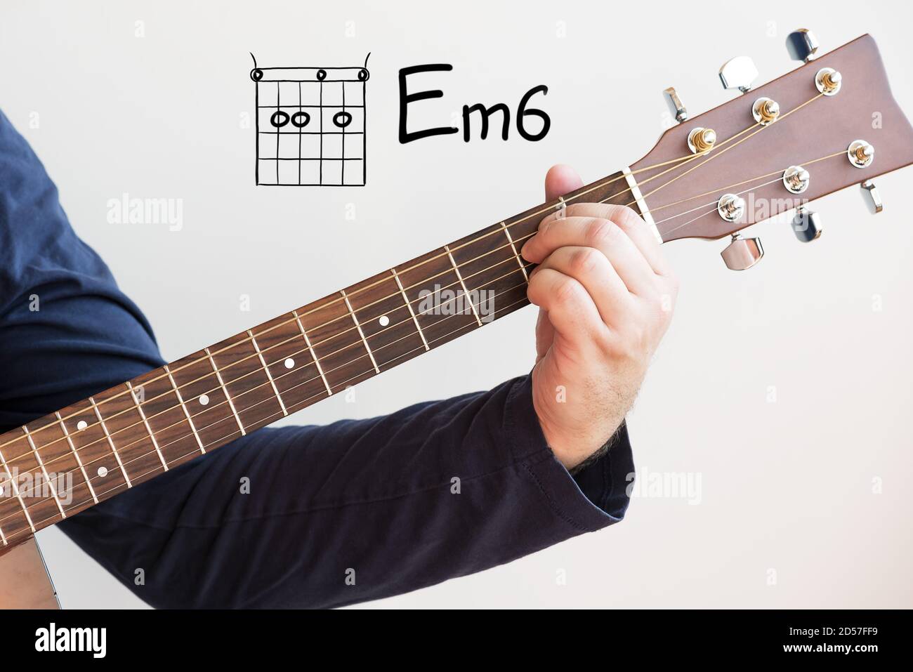 Gitarre lernen - Mann in einem dunkelblauen Hemd spielen Gitarrenakkorde auf Whiteboard angezeigt, Chord E Minor 6 Stockfoto