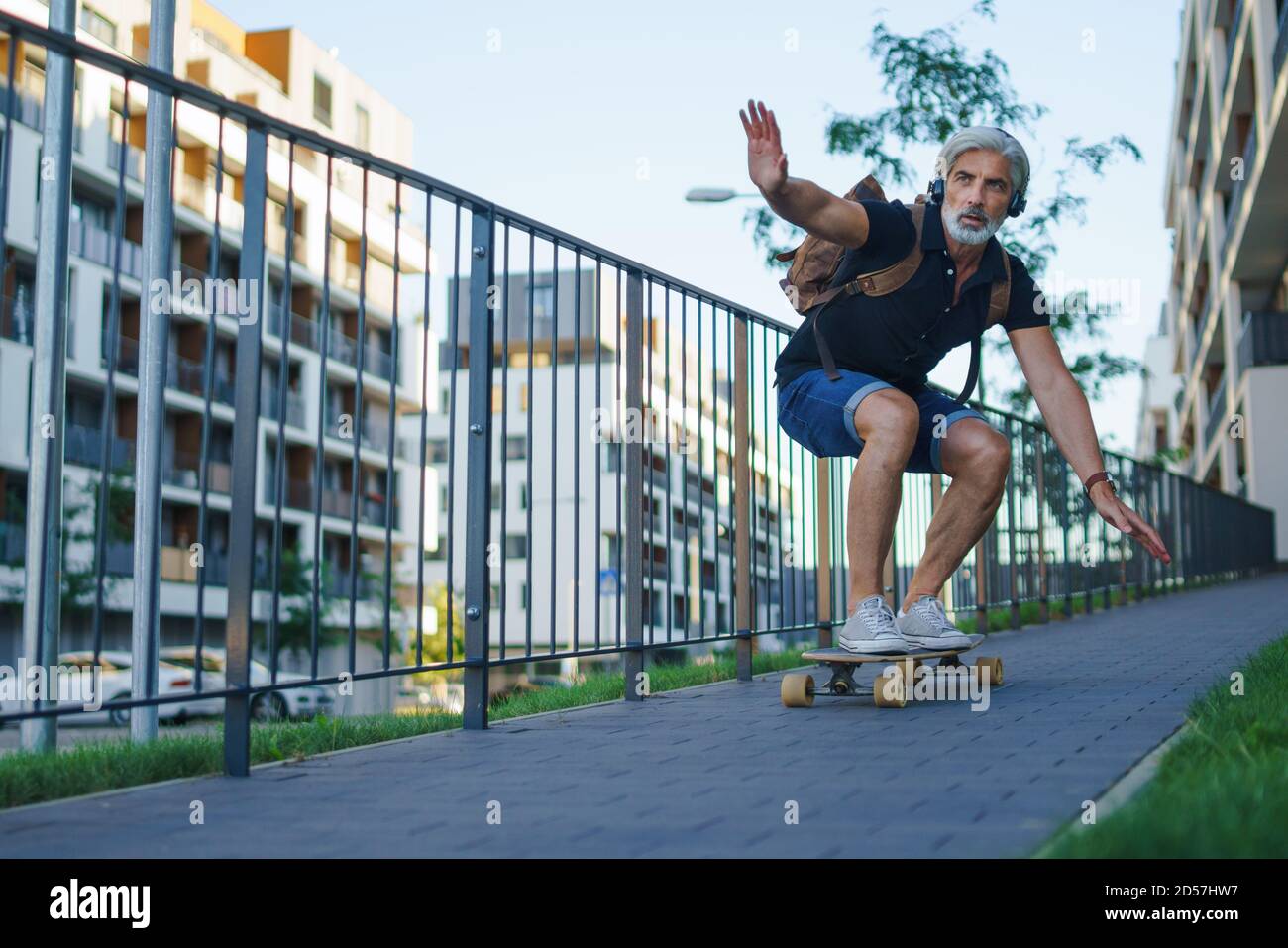 Portrait von reifen Mann Reiten Skateboard im Freien in der Stadt, gehen zurück zur Arbeit. Stockfoto