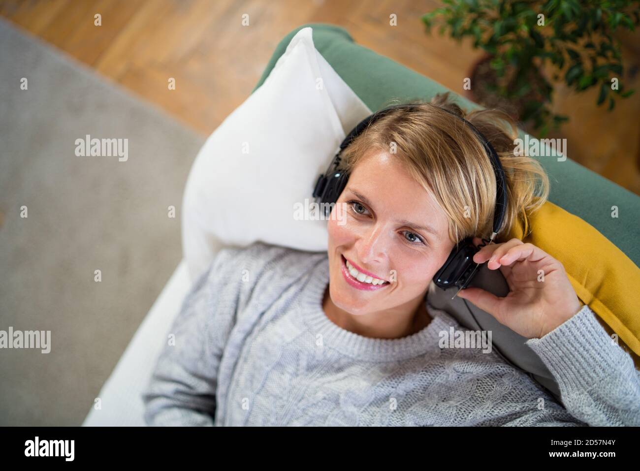Portrait der Frau mit Kopfhörern Entspannung drinnen zu Hause, psychische Gesundheit Konzept. Stockfoto