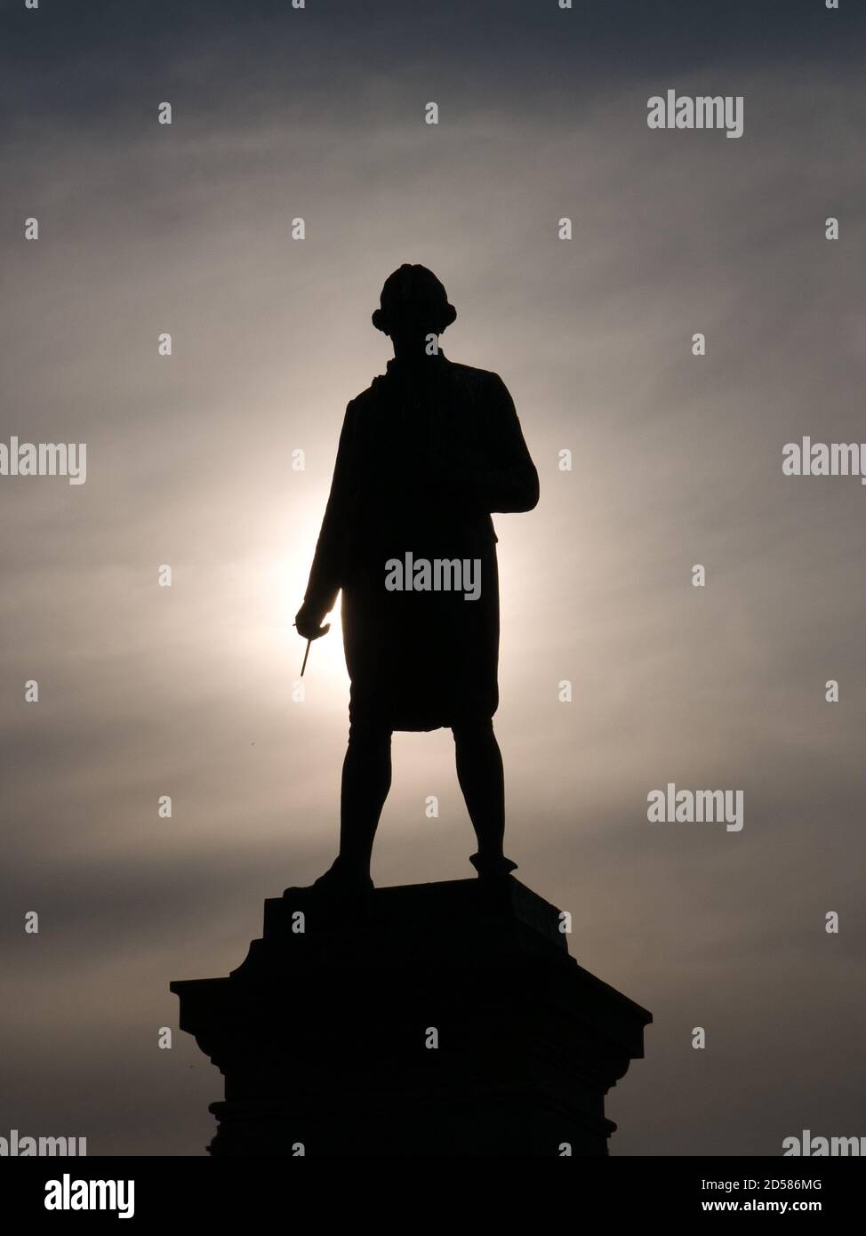 Die Bronzestatue von Captain James Cook in Whitby, North Yorkshire, Großbritannien, wurde an einem späteren Sommerabend gegen die untergehende Sonne geschildet Stockfoto