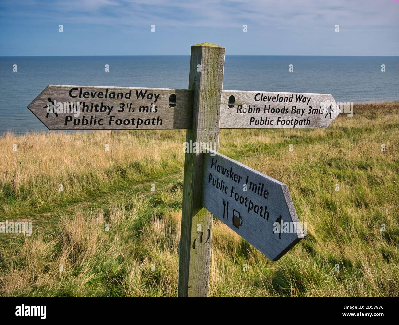 Ein hölzerner Wegweiser auf einem Küstenabschnitt des Cleveland Way National Trail zwischen Robin Hood's Bay und Whitby in North Yorkshire, England, Großbritannien Stockfoto