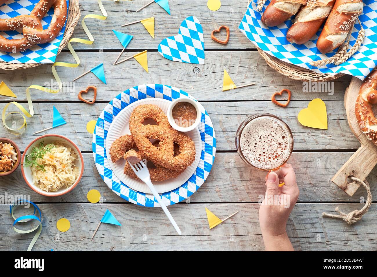 Oktoberfest, allein feiern. Traditionelles Essen und Bier, Blick von oben auf Holztisch, Stockfoto