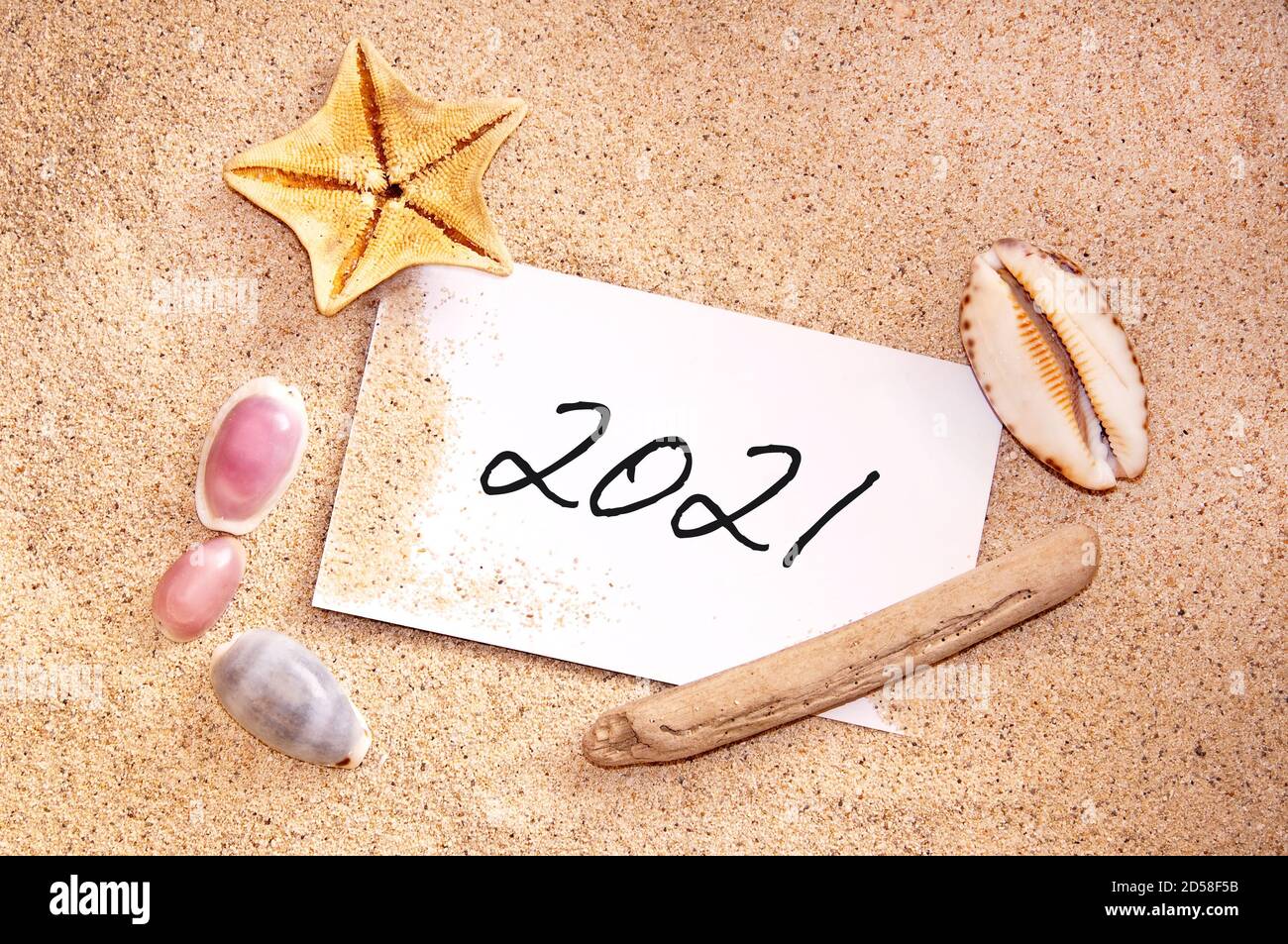 2021 geschrieben auf einem Zettel im Sand eines Strandes mit Muscheln, tropischen Ferien, Neujahr Urlaubskarte Stockfoto