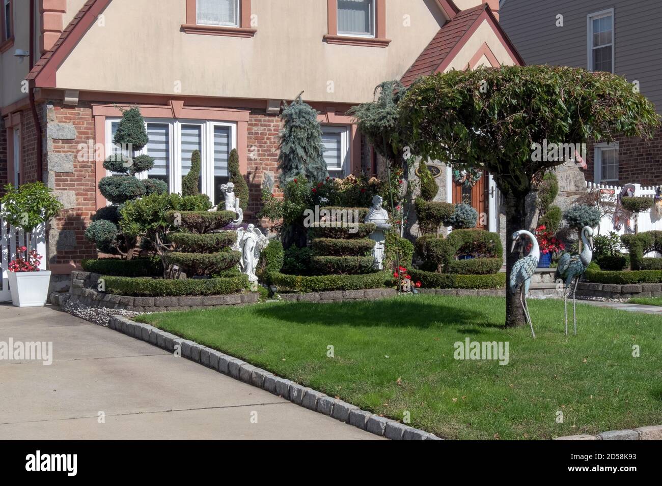Das Äußere eines Privathauses in Flushing Queens New York mit Topiary, Flamingos und religiösen Statuen. Stockfoto