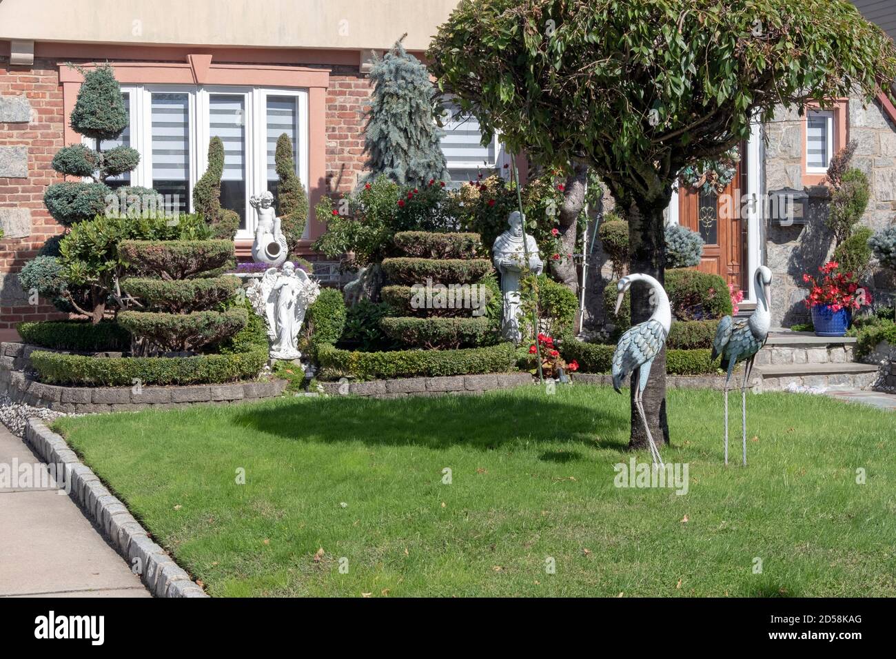 Das Äußere eines Privathauses in Flushing Queens New York mit Topiary, Flamingos und religiösen Statuen. Stockfoto